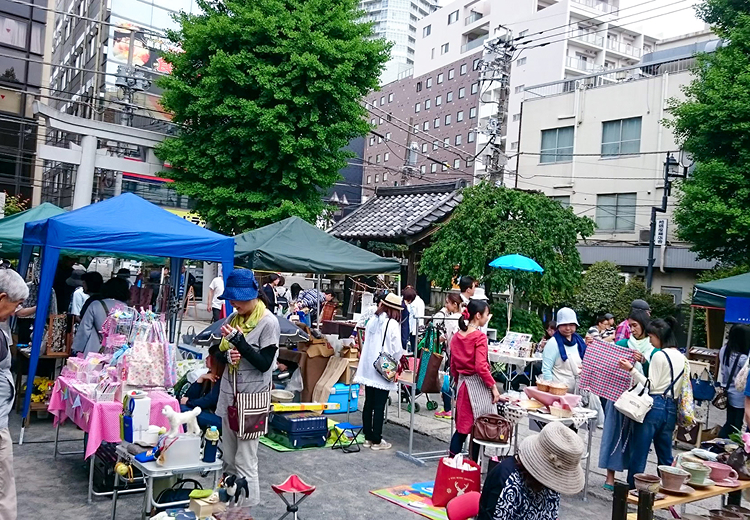 青空の下でテントを張った出店ブースに集まる来場者たち